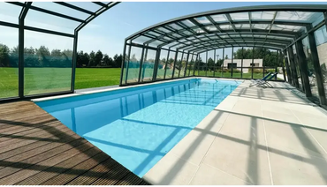 Blå inomhuspool i Bahama trädgårdspool med transparent pooltak