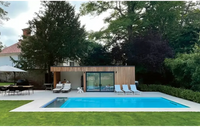 Modern design Leisurepools Cube utomhuspool med träklädd poolhus och stora glasdörrar