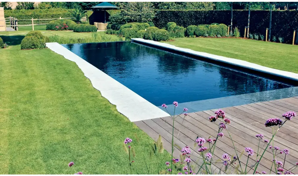 Modern design Leisurepools Cube infinity pool med mörkblått vatten och vita betongkanter