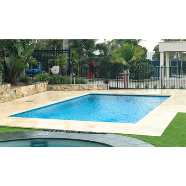 Leisurepools Elite rektangulär modern pool med klarblått vatten och beige sten