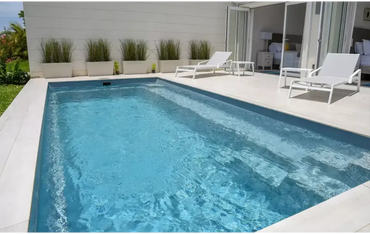 Leisurepools Harmony medence – téglalap alak, tiszta, kék víz, fehér csempével burkolt peremek