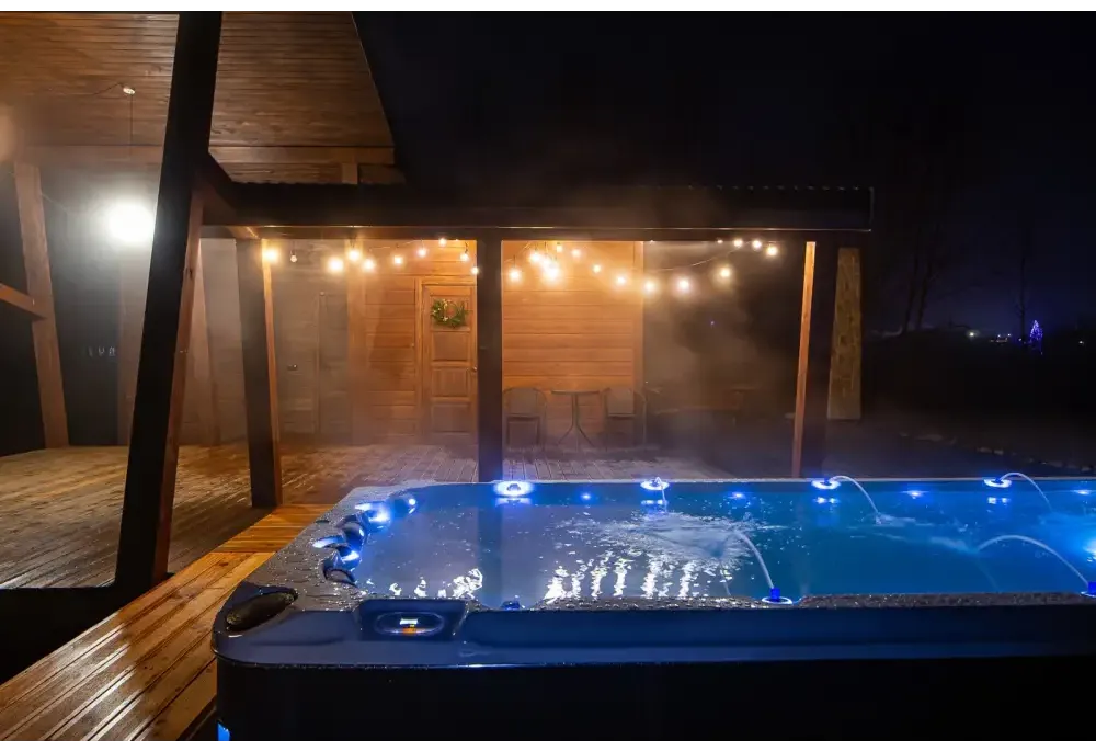 Blå upplyst PassionSpa Activity 2 Deep Swim Spa med jetstrålar och grå texturerad yta