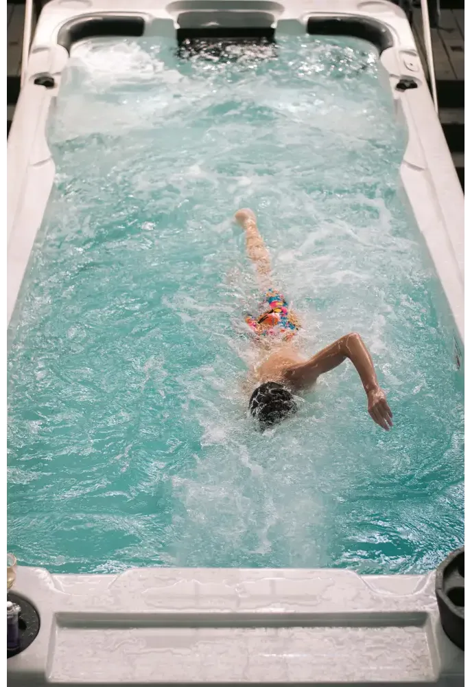 Person simmar i PassionSpa Aquatic 2 Swim Spa med turkost vatten