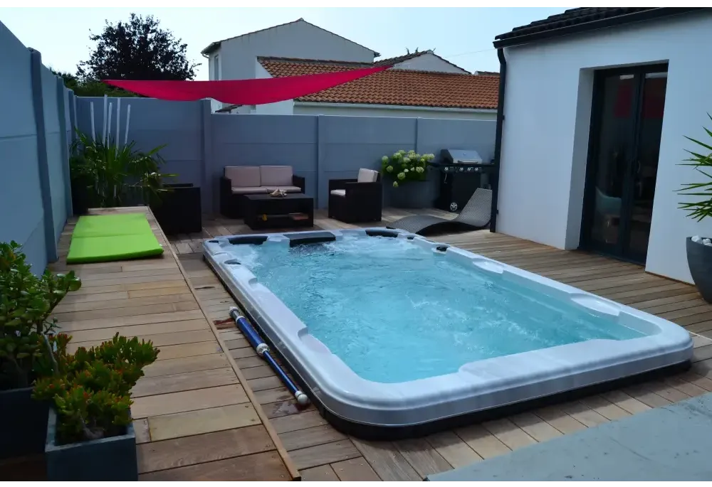Vit PassionSpa Aquatic 2 Swim Spa i Sport Collection med blåvatten på trädäck