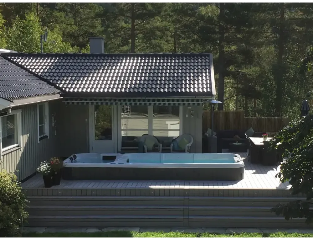 Grå PassionSpa Aquatic 3 Deep Swim Spa med blåvatten på trädäck