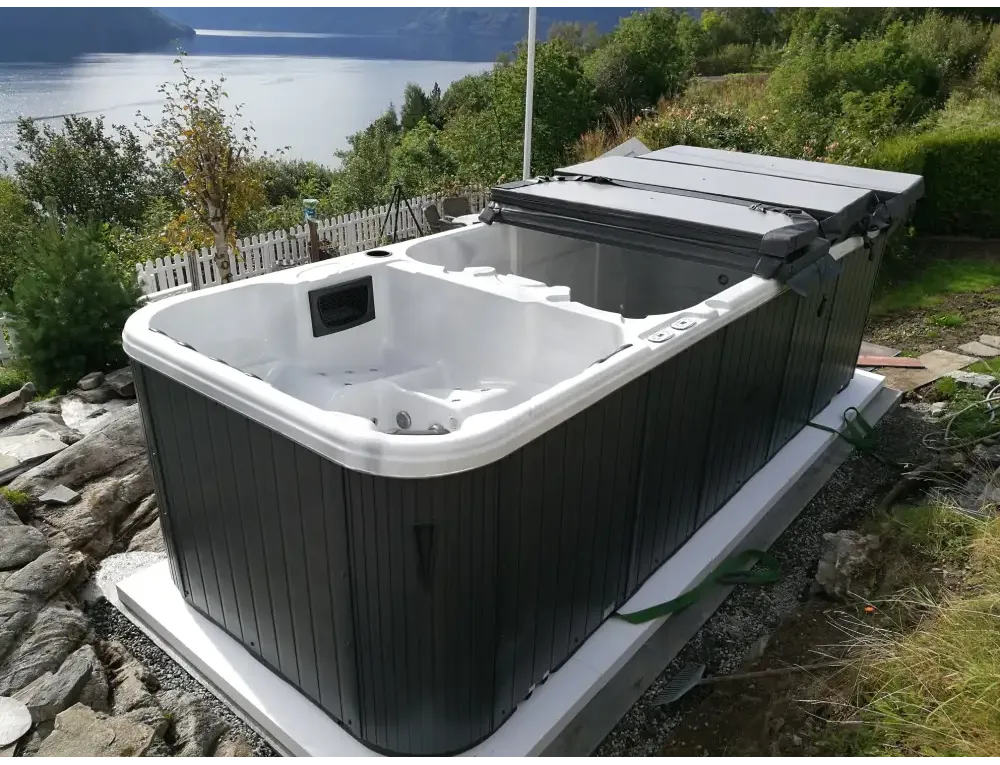 Svartvit PassionSpa Aquatic 3 Swim Spa med modern vertikal panelning utomhus