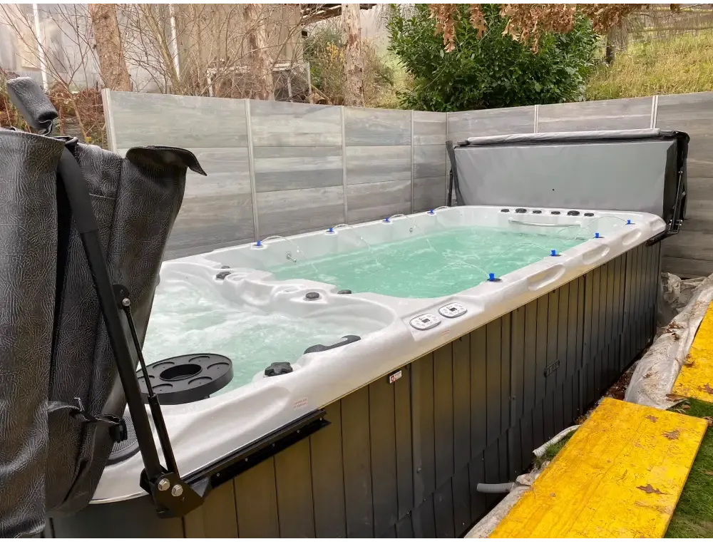Vit och svart PassionSpa Spirit Swim Spa med turkost vatten och jetmunstycken