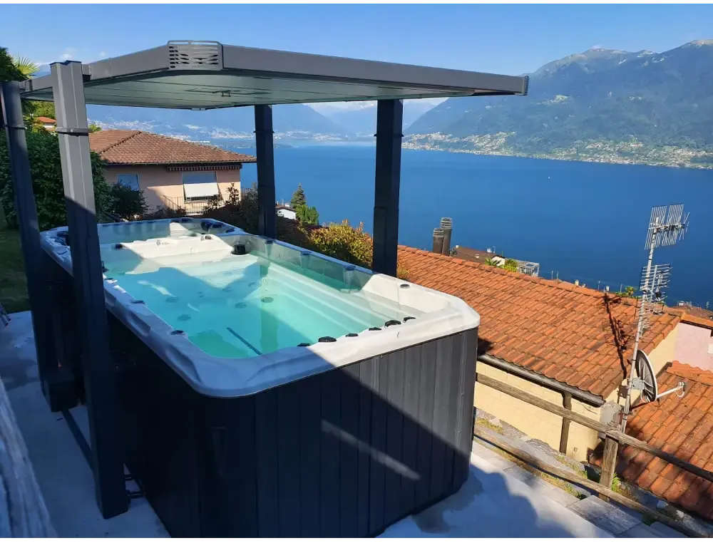 Svartvit PassionSpa Spirit Swim Spa med tak på takterrass vid sjö
