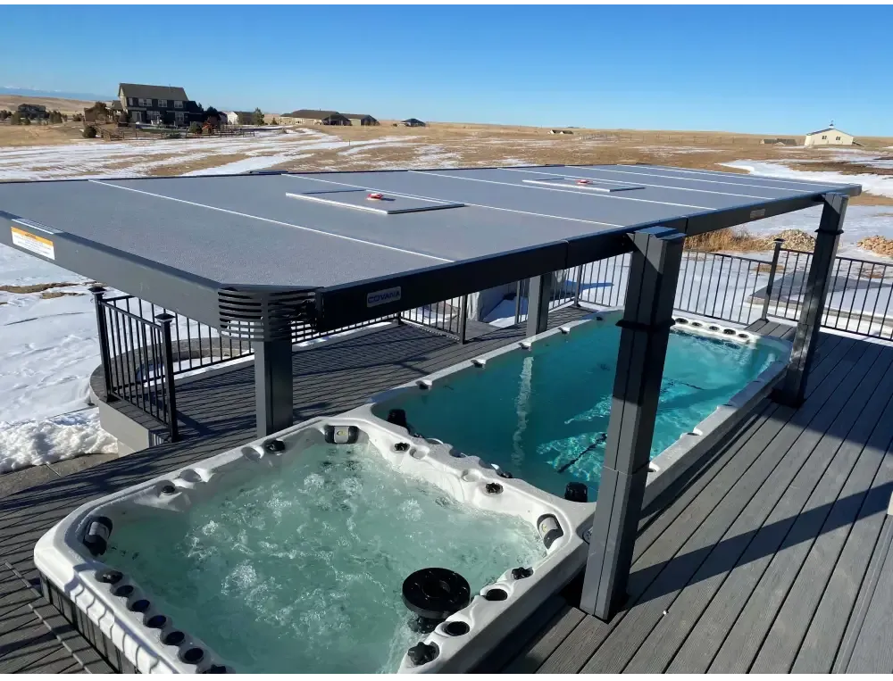 Grå solpanelstak med svart metallram över PassionSpa Vitality Swim Spa-däck