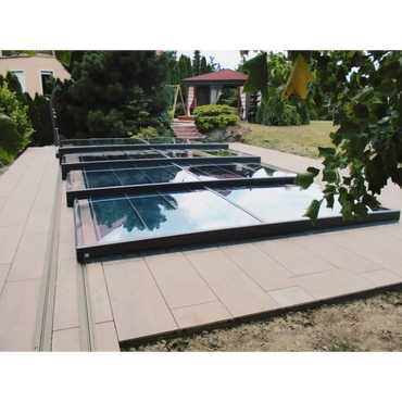 Pooltak Mästare Plus med modern glasdesign och svart ram över kaklat uteplats