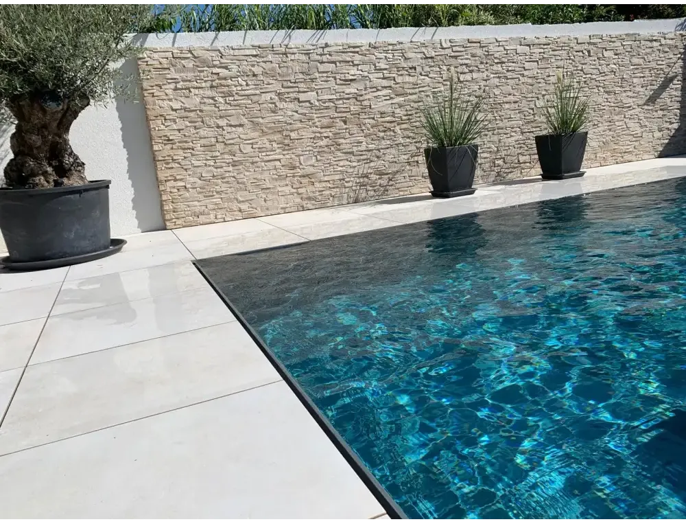 Pooltime Exklusiv overflow med klart turkost vatten och svarta kakelkanter